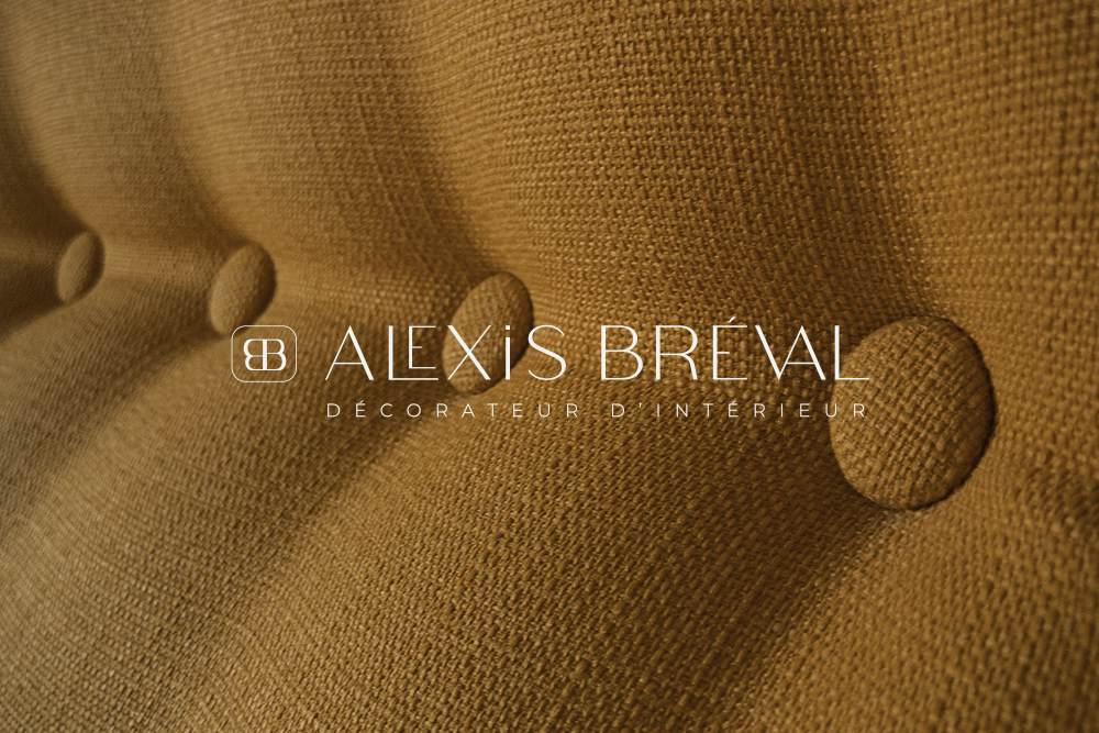 le logo d'un décorateur d'intérieur placé sur une texture de tissu avec des boutons.